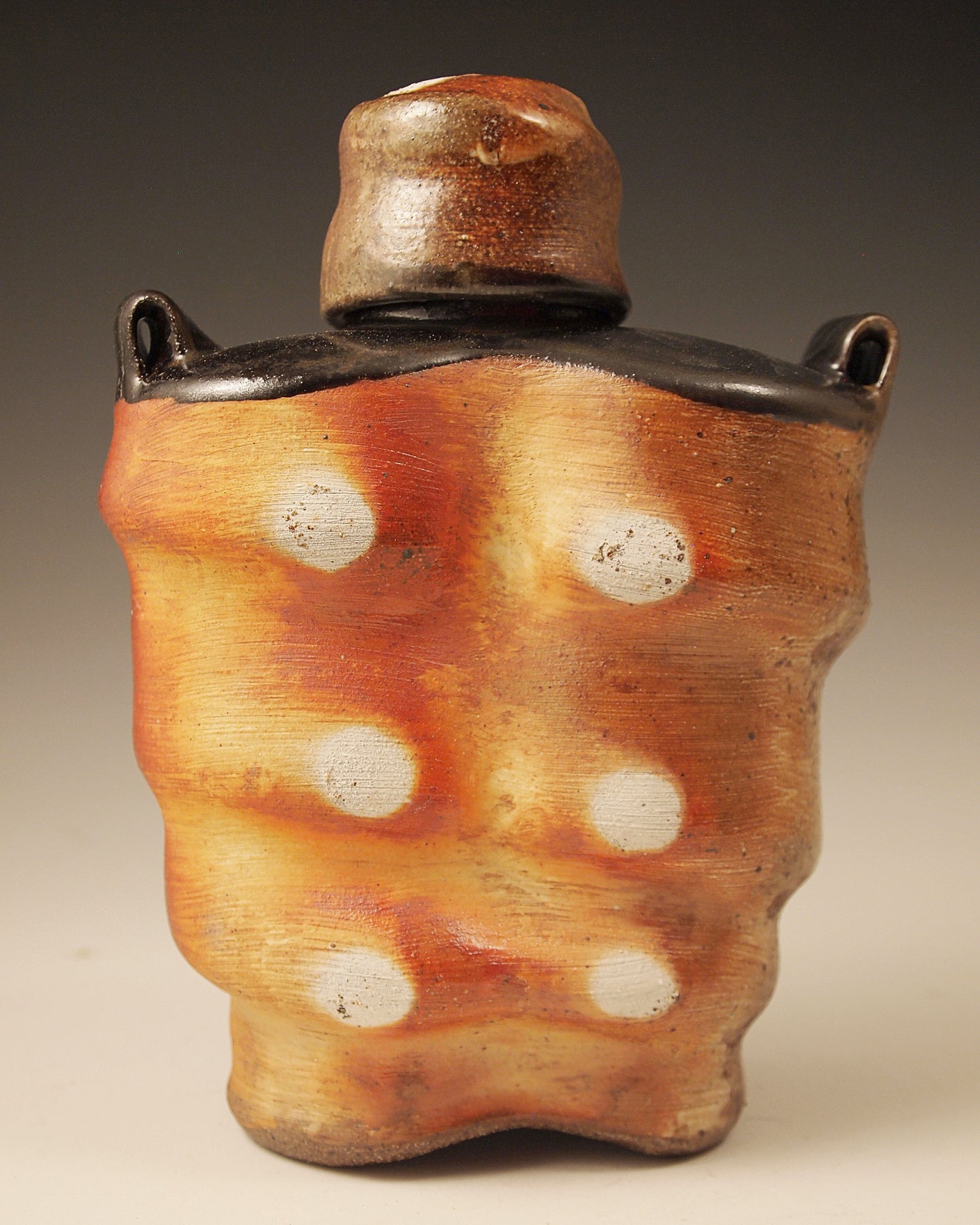 Wood-fired Stoneware Whiskey Flask with black liner glaze and black shoulders. Handmade. One-of-a-kind ceramic flask. 7" tall. 5.5" wide. 3" deep. 